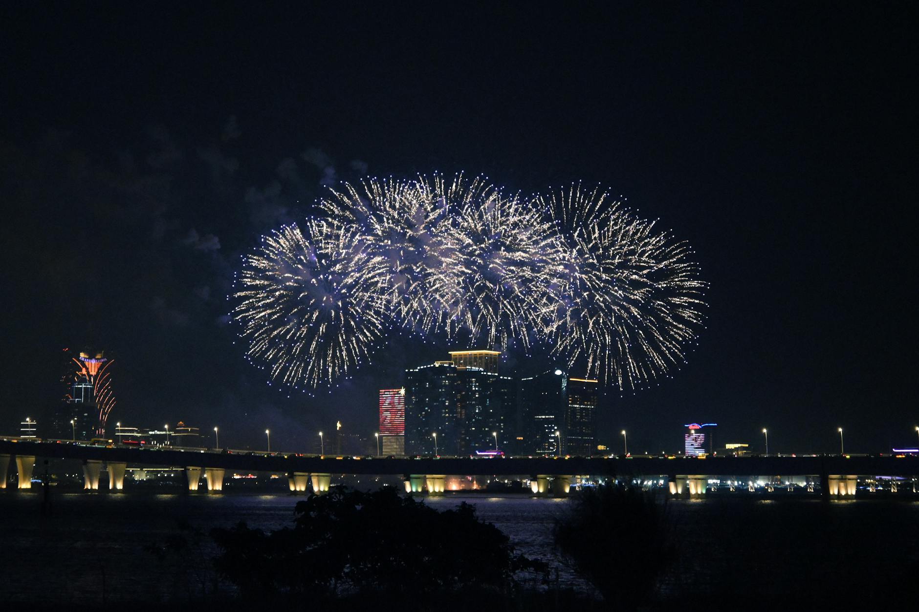 photo of fireworks above illuminated modern city skyline