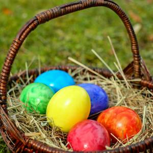 wicker basket with easter eggs on hay