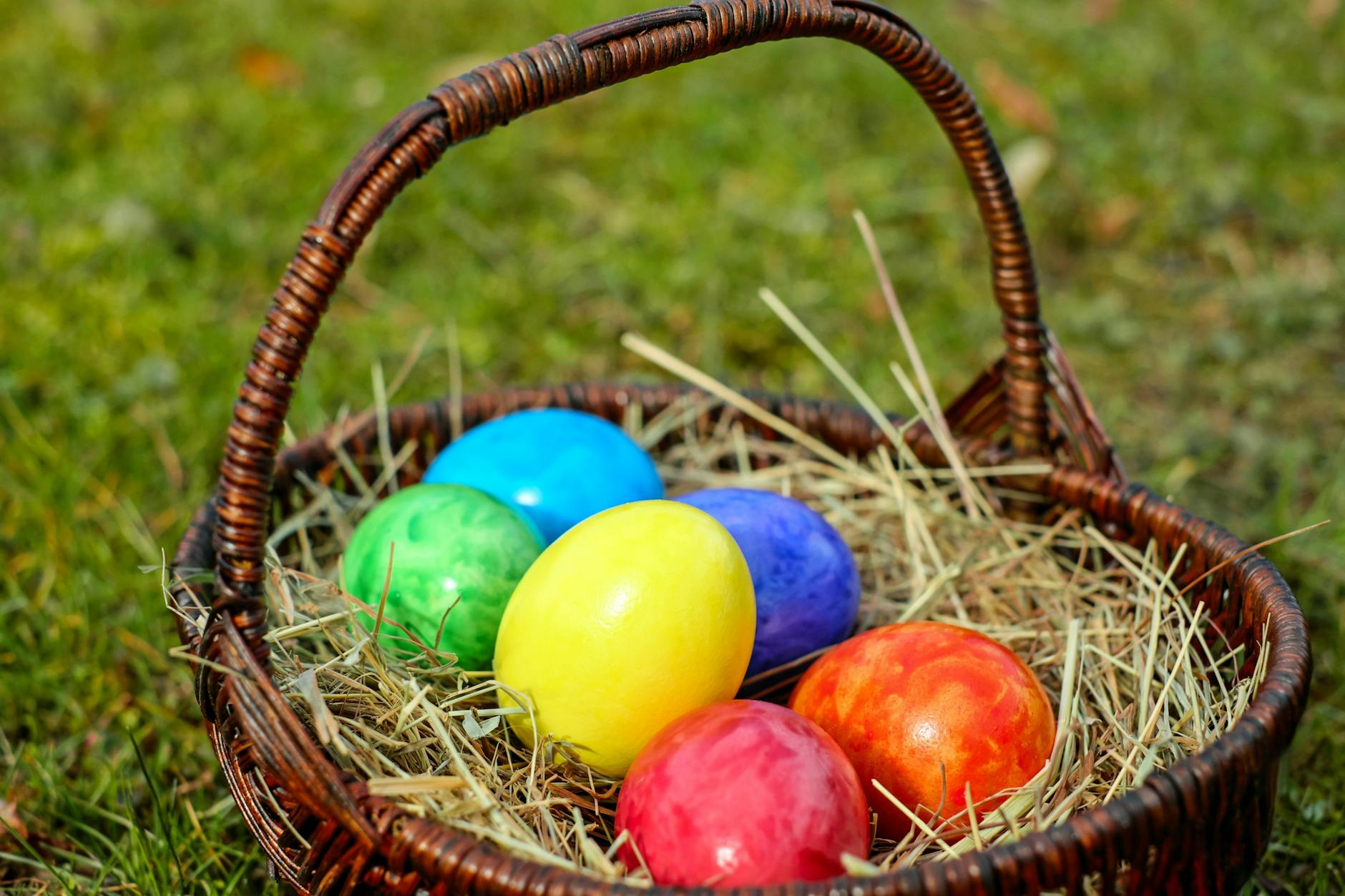 wicker basket with easter eggs on hay