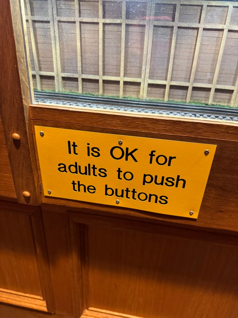 Sign at the San Diego Model Railroad Museum that says it is OK for adults to push the buttons